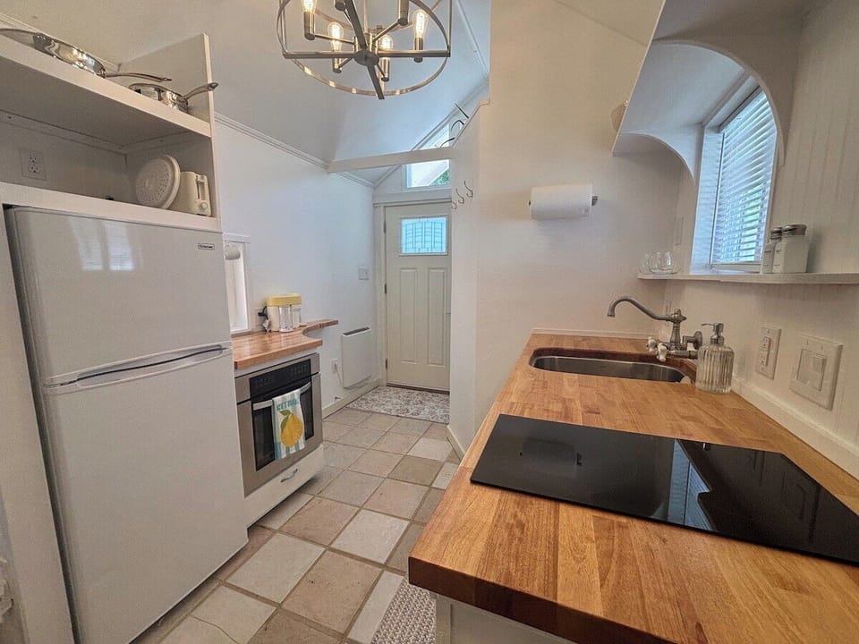 Fully equipped kitchen with cooktop, oven, and butcher block counters