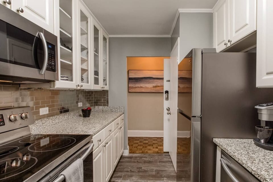Functional kitchen layout w/ ample counter space & view toward adjacent room