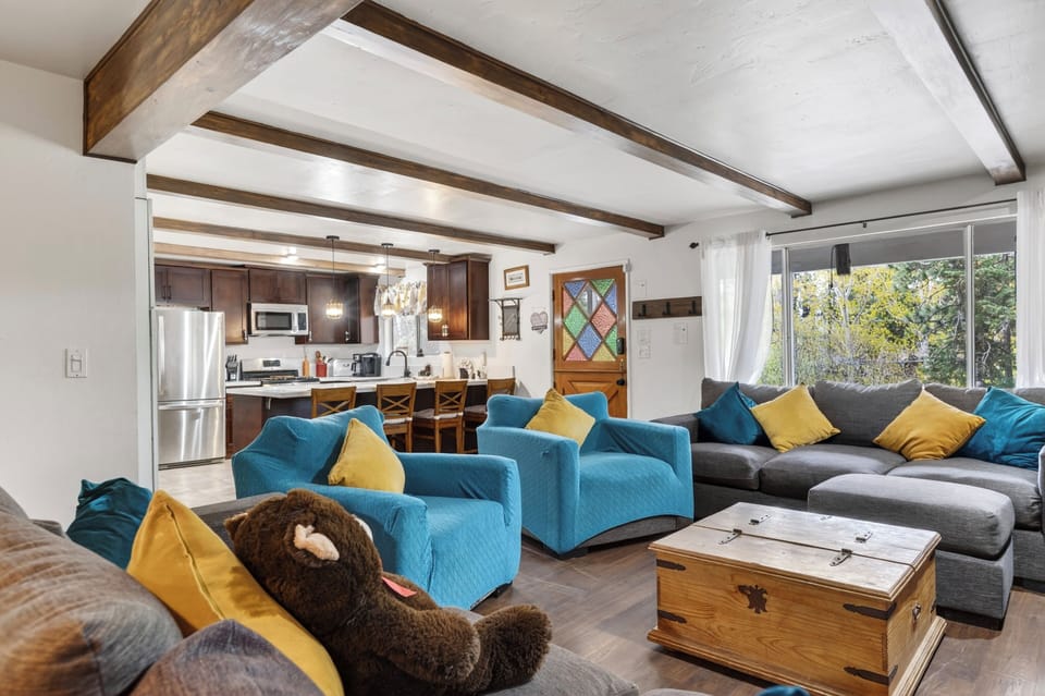 Cozy living area with stone fireplace, exposed beams, and comfortable seating.