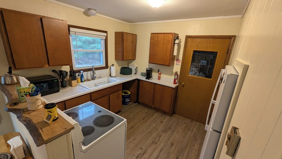 Stove, Microwave, Keurig, and all new pots + pans, and table ware in cupboards.