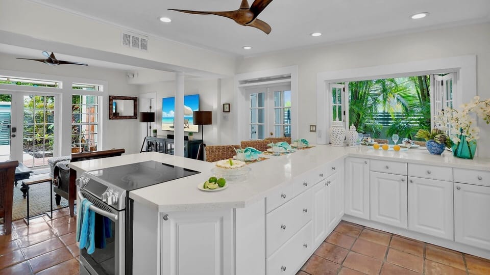 Picture yourself preparing meals in this bright kitchen with ocean breezes flowing through the open windows, tropical palms swaying outside, and coastal charm surrounding you at every turn.