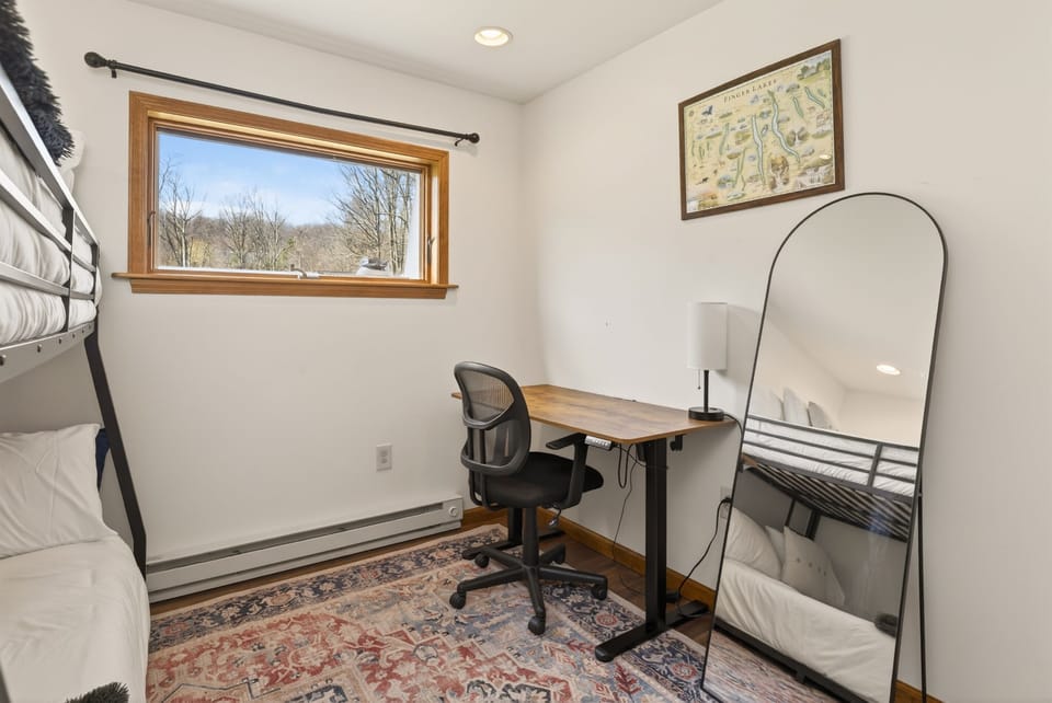 Guest bedroom with desk and additional sleeping space