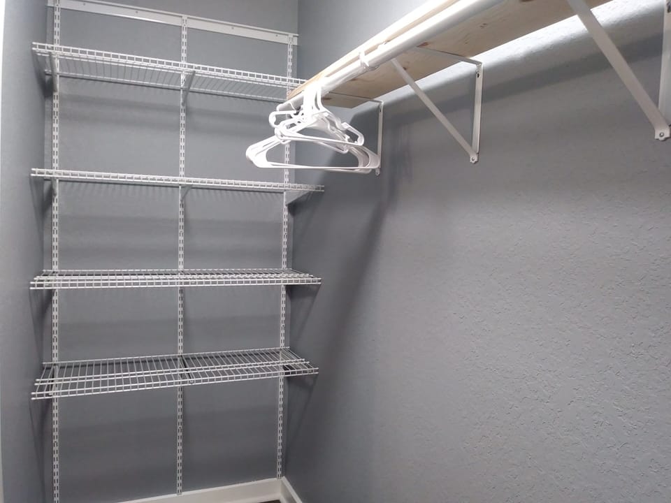 Bedroom 3 closet has lots of room and wire shelving on both sides.