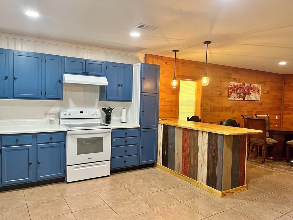 Kitchen bar, electric range and vent,  cabinets 