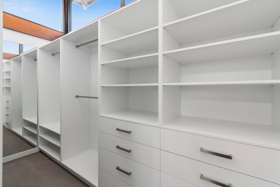 Unpack and feel instantly at home in the second bedroom’s walk-in robe, with open shelving, hanging space and drawers making it easy to organise your stay.