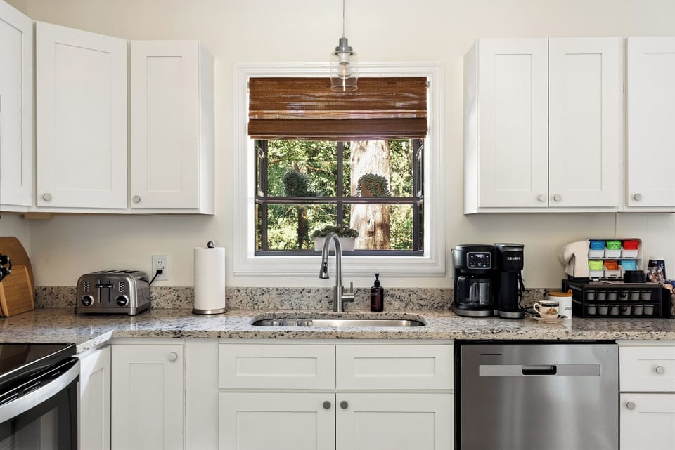 Bright kitchen with stainless appliances and serene window views