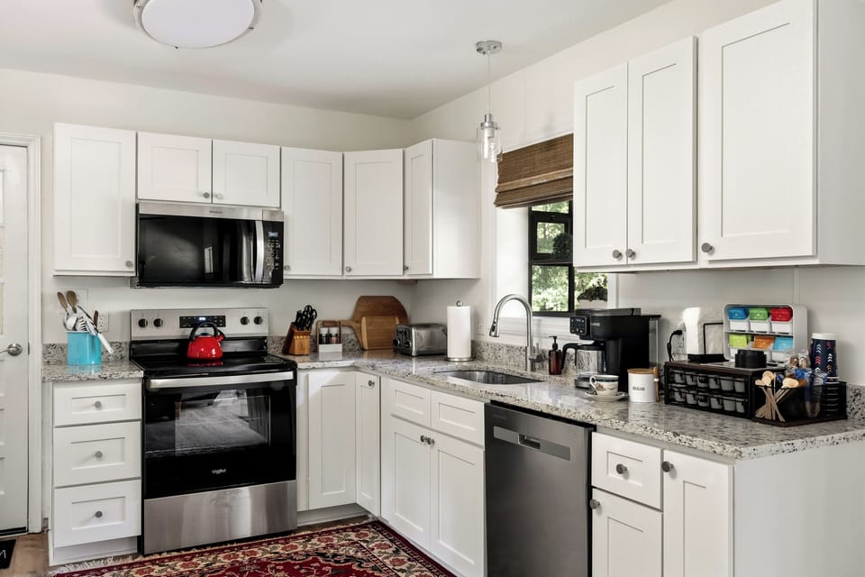 Bright modern kitchen with granite counters, coffee station, and stainless appliances