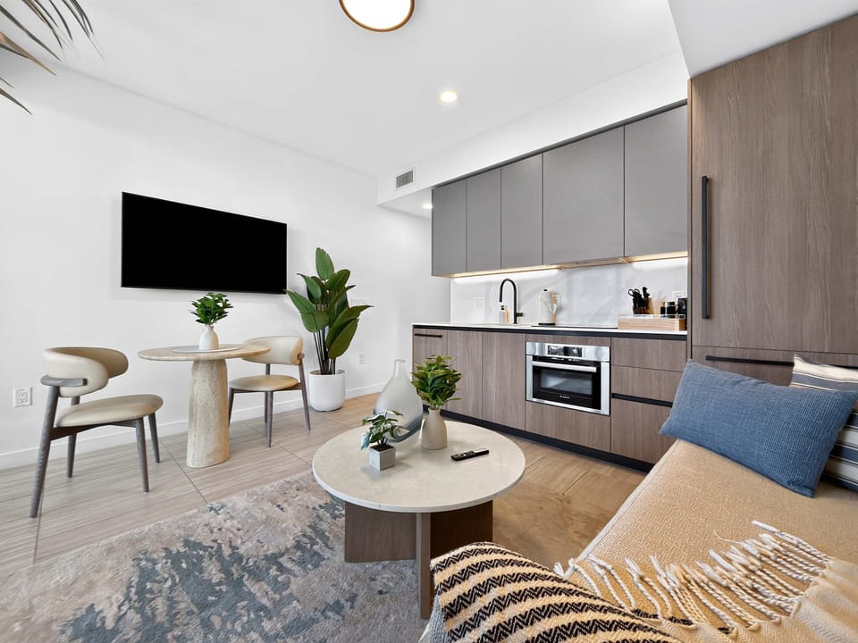 Bright and cozy living area with smart TV and comfy seating.