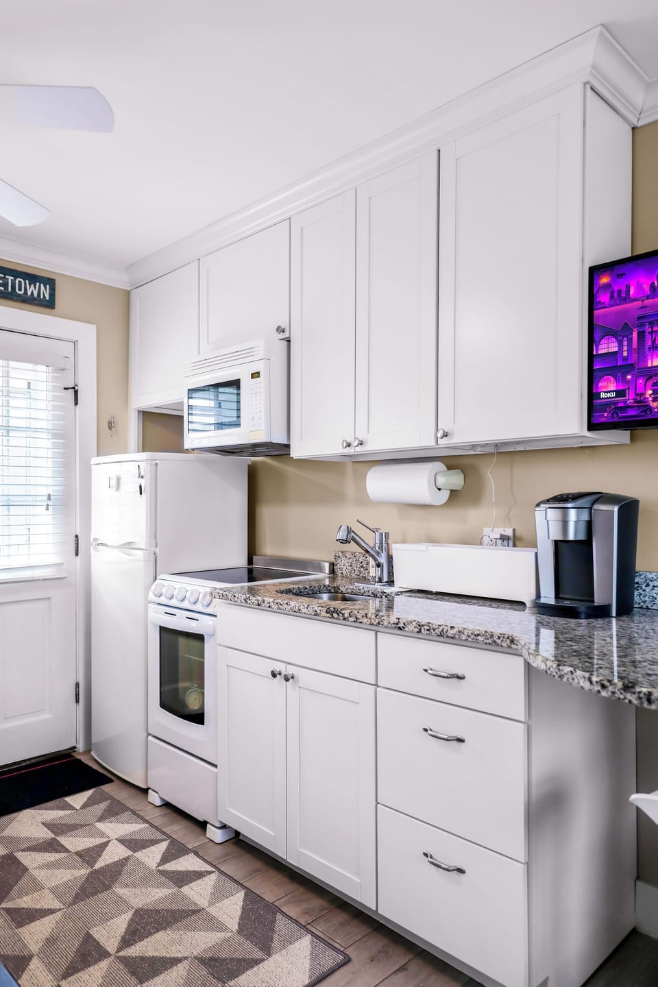 Bright kitchen with granite counters, full appliances, and plenty of storage