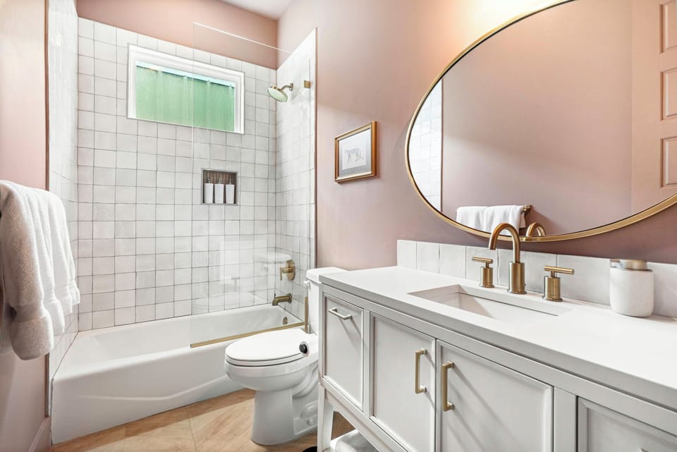 Bright modern bathroom with tiled tub-shower and stylish brass finishes