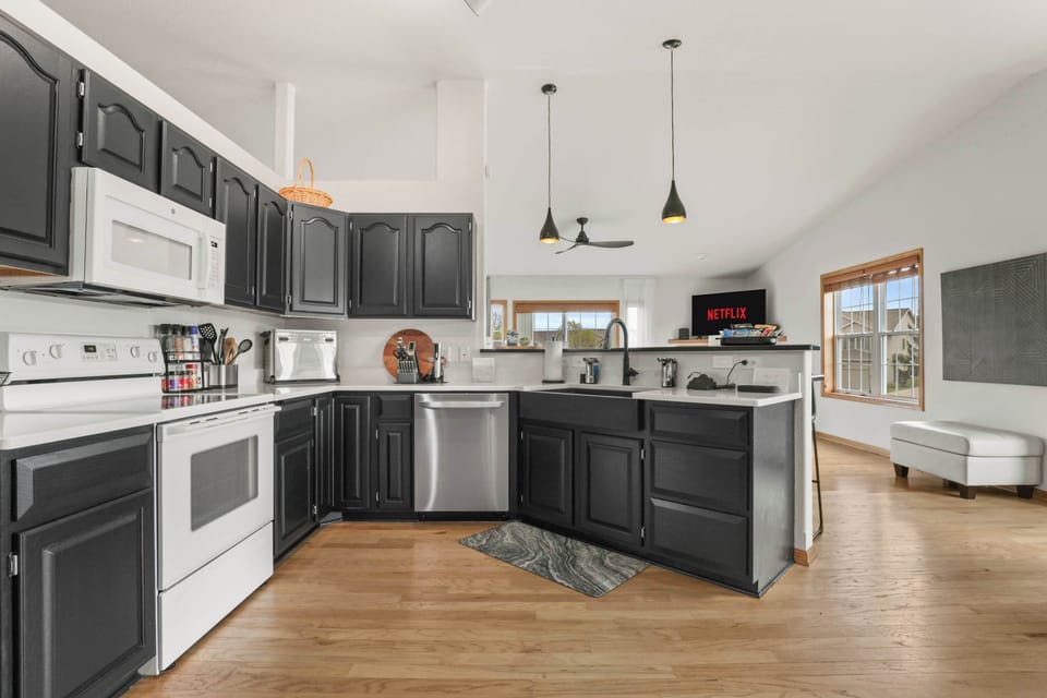Fully stocked kitchen with 4 barstools at the breakfast bar, complimentary coffee station, 5 seat dining table, and visibility to the living room.