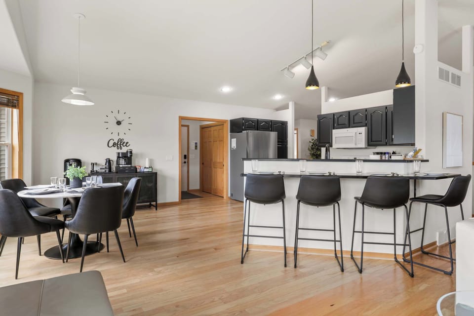Fully stocked kitchen with 4 barstools at the breakfast bar, complimentary coffee station, 5 seat dining table, and visibility to the living room.