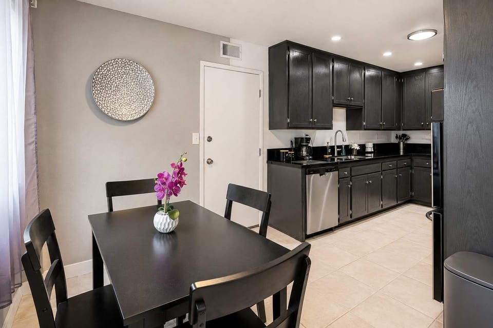 🍳 Enjoy cooking indoors or grilling on the BBQ.
dark cabinetry and a cafe table for casual meals close to the action.