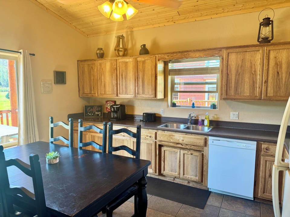 Rustic full kitchen with dining space, natural light, and deck access