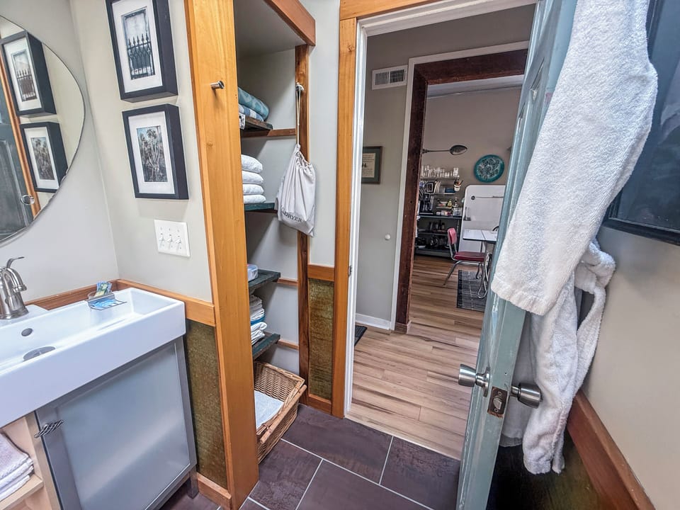 Bright bathroom with stocked open shelving and stylish modern touches
