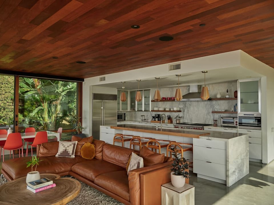 Leather, marble, wood pendants, and a tropical garden right outside. This kitchen was made for entertaining