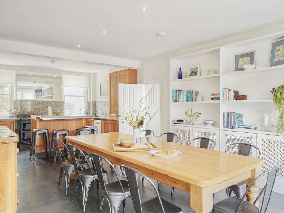 
Contemporary dining area with long wooden table and open-plan design