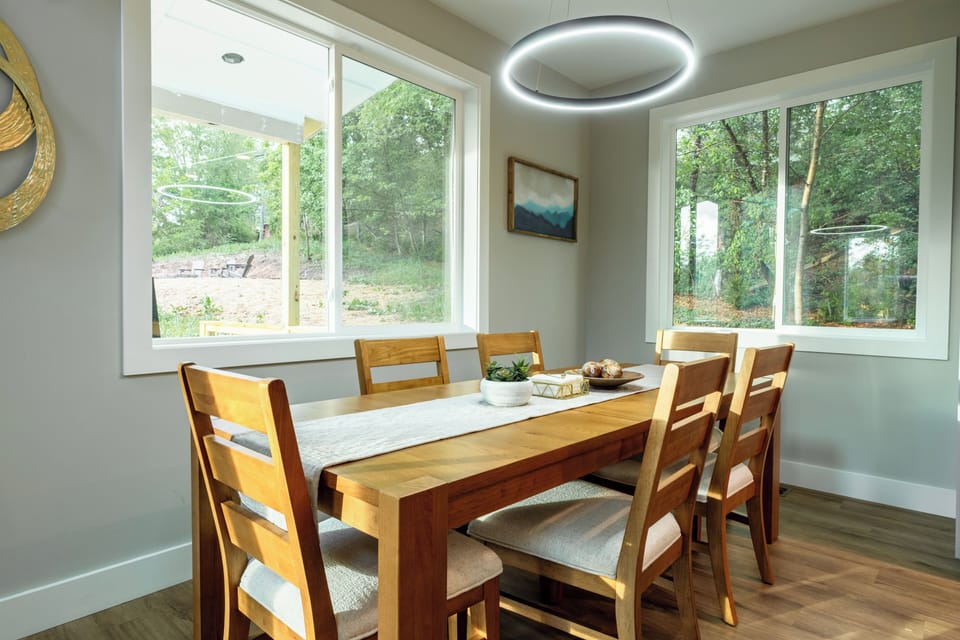 Bright dining nook with forest views, modern halo light, seating for six
