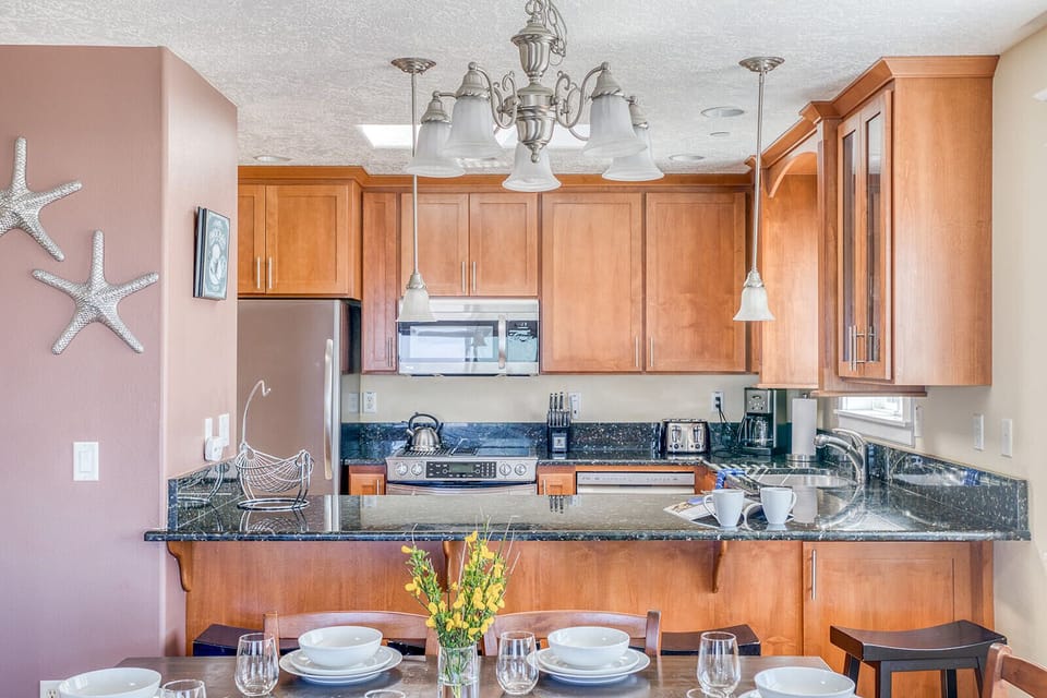 Your fully-equipped kitchen with granite countertops and breakfast bar creates the perfect space for coastal-inspired meals.