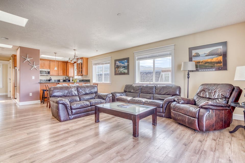 Sink into plush leather seating in your spacious living room, where warm tones and natural light create the perfect spot for relaxation.
