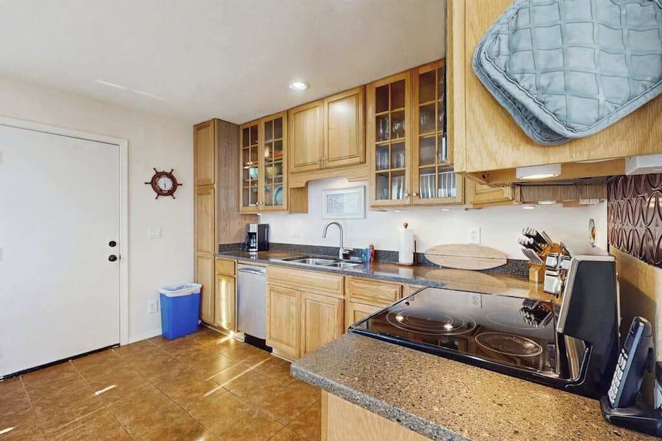 Cleanup is a breeze with a built-in dishwasher and generous counter space — nautical touches like the life ring on the wall remind you that the ocean is just moments away.