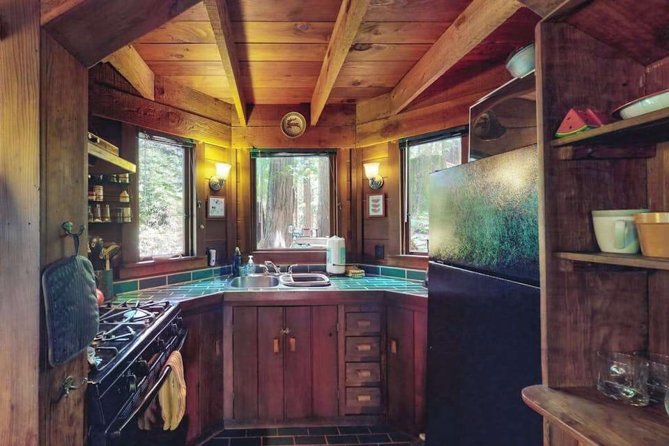 Whip up Sonoma-inspired meals in your cozy galley kitchen — a gas range, artisan tile backsplash, and redwood forest views through the window make cooking a delight.