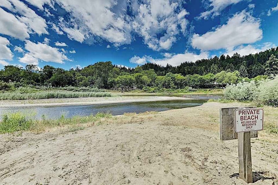 Your own private beach on the Russian River — sandy banks, calm water, and forested bluffs with no crowds in sight.