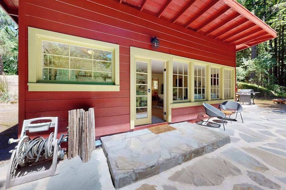 Relax on your spacious stone patio with a lounge chair and a Sonoma rosé — the covered overhang and French doors make indoor-outdoor living effortless.