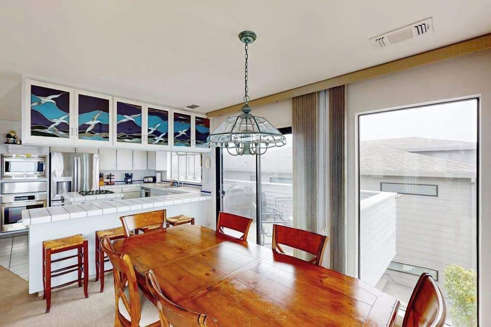 Share fresh Sonoma Coast seafood at your wooden dining table beneath artisan stained-glass panels capturing the colors of the Pacific