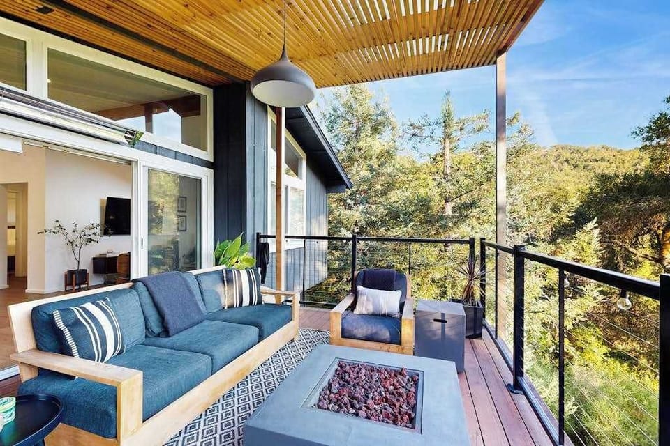Covered deck lounge with plush seating and a fire pit table framing mountain views — your Healdsburg evening ritual starts here.