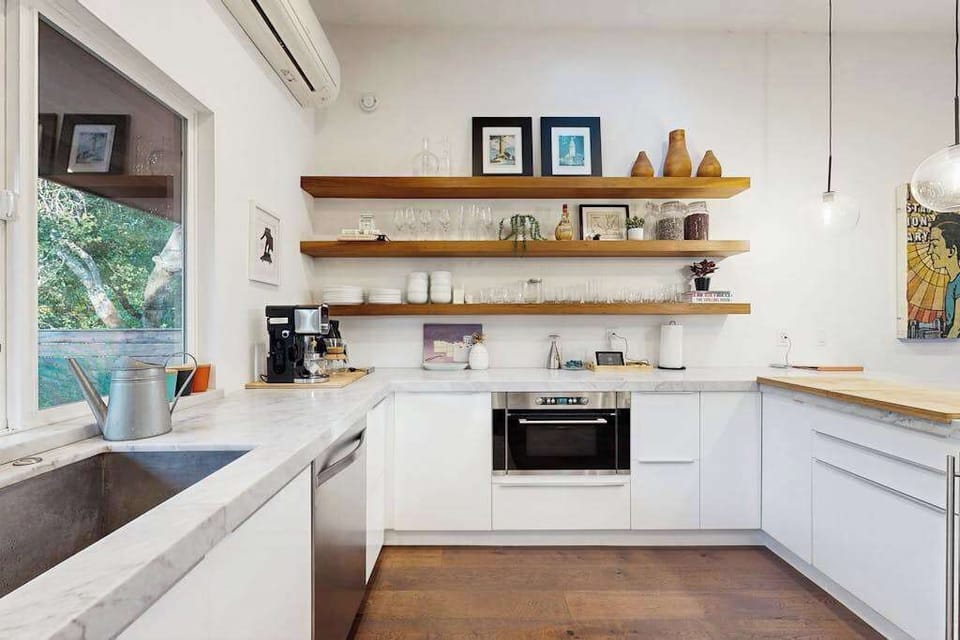 Brew your morning coffee in a chef's kitchen with marble countertops, open wood shelving, and wine glasses ready for your Healdsburg haul.