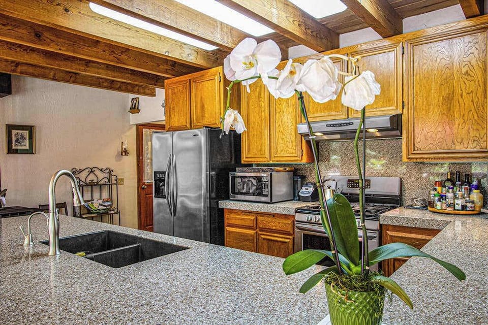 Fresh orchids and natural skylight glow greet you at the granite island — your fully stocked kitchen has everything for Sonoma wine-paired dinners.