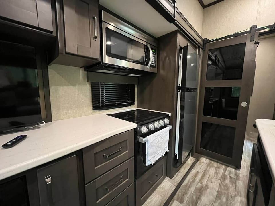 Kitchen island, microwave, stove, and entry inside The Mountain Nook