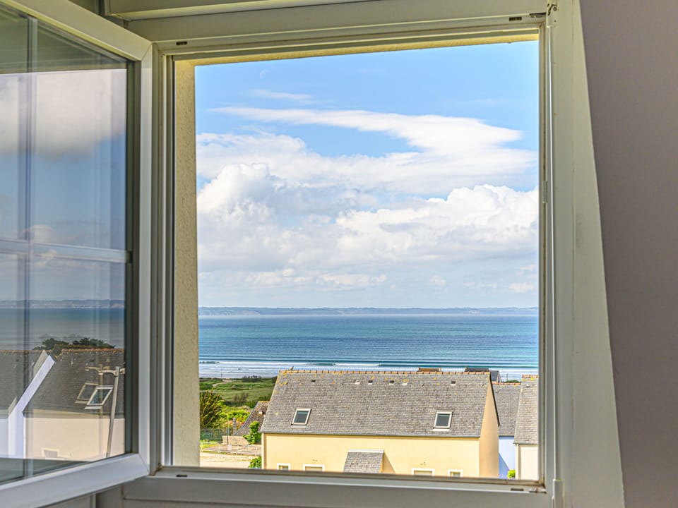 Upper-floor window framing the Bay of Douarnenez — sea views from the moment you wake up