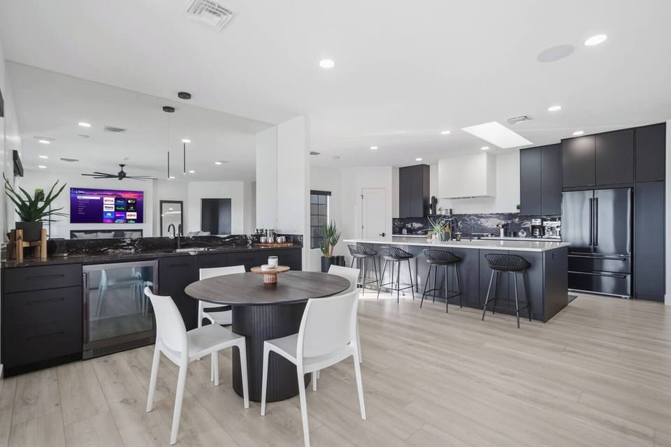 Designer kitchen and dining area featuring a large island with seating and a dedicated wet bar.