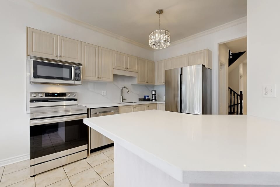 Clean, white countertops and breakfast bar seating.