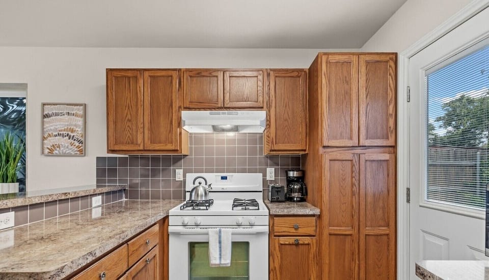 Fire up the gas stove and spread out — tall pantry and granite counters keep everything handy.
