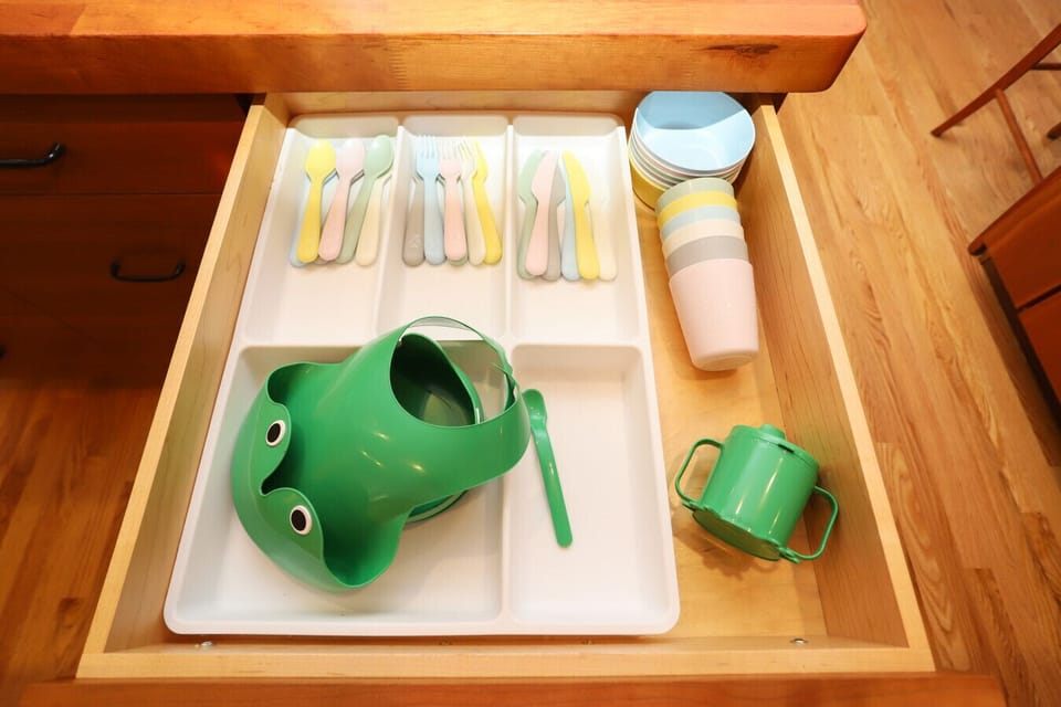 Utensils, cups and bowl for kids provided, including a sippy cup, washable bib and plate.