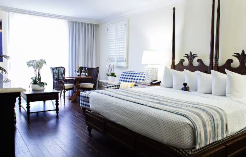Wake up in crisp linens beside sunlit windows and seating.