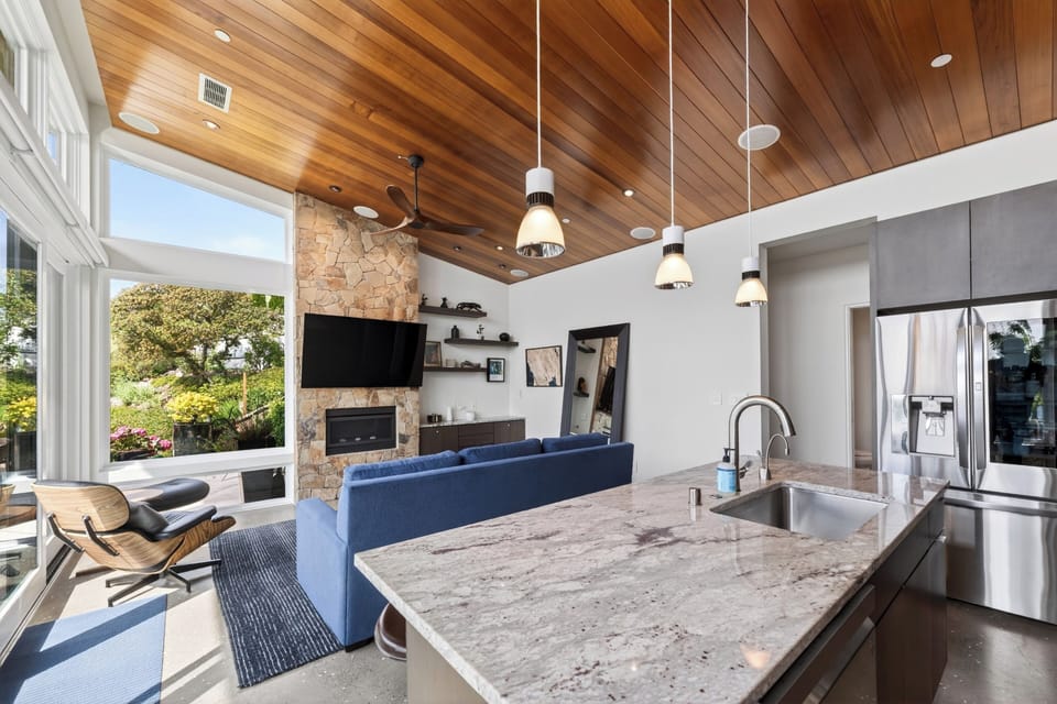Bright and airy living space with vaulted wood ceilings and designer lighting.
