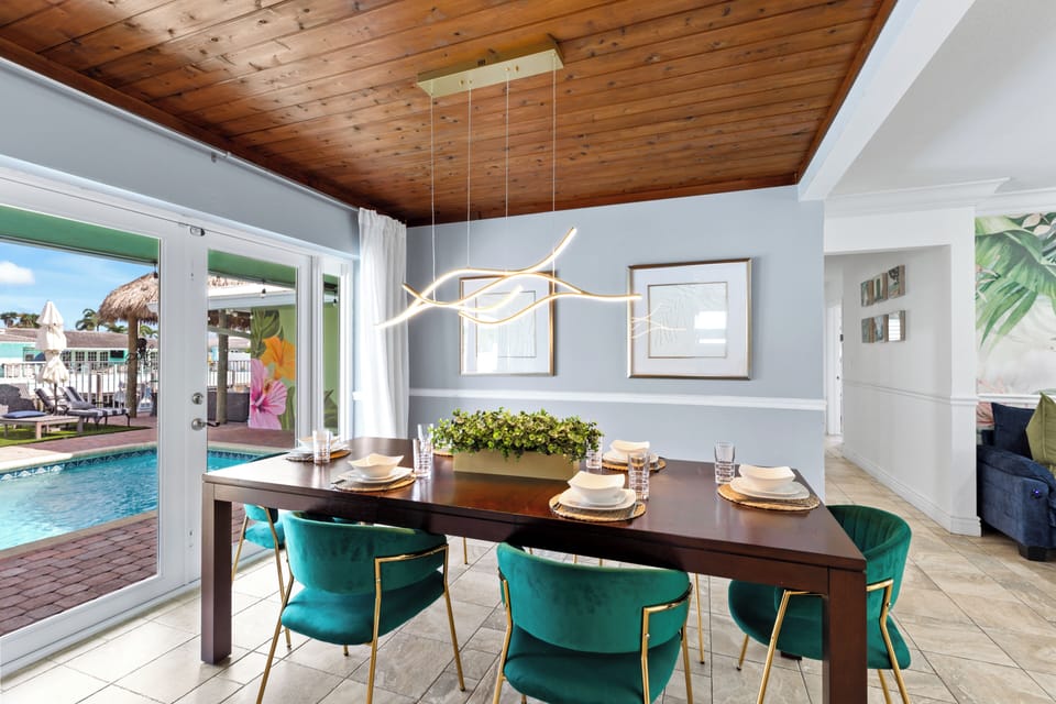 Formal dining area with seating for eight and a modern chandelier.