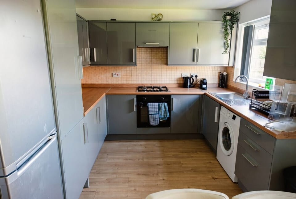 Well-equipped kitchen with washing machine, gas oven, and Nespresso machine.