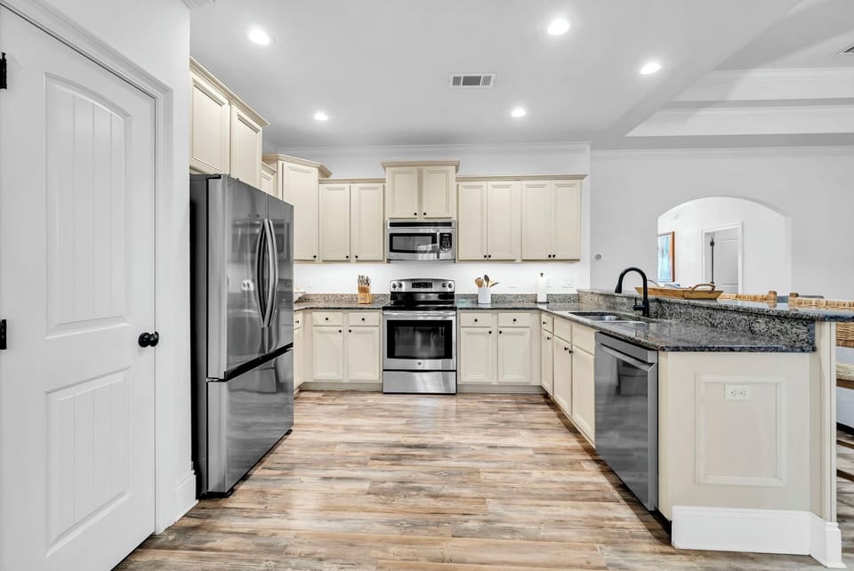 Your spacious kitchen features granite countertops, stainless steel appliances, and plenty of cabinet storage for preparing memorable meals during your stay.