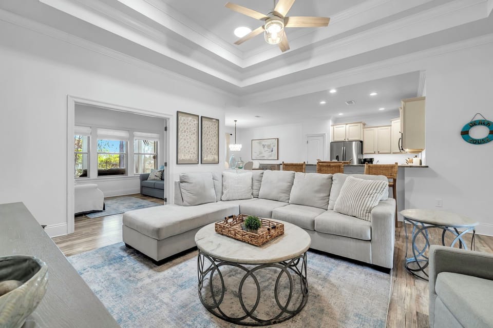 Unwind in your spacious living room where elegant ceiling beams meet plush seating, creating the perfect spot to relax after coastal adventures.