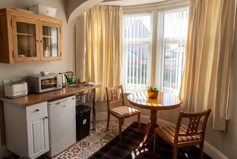 A sunny bay window breakfast nook with a full kitchenette at your fingertips.