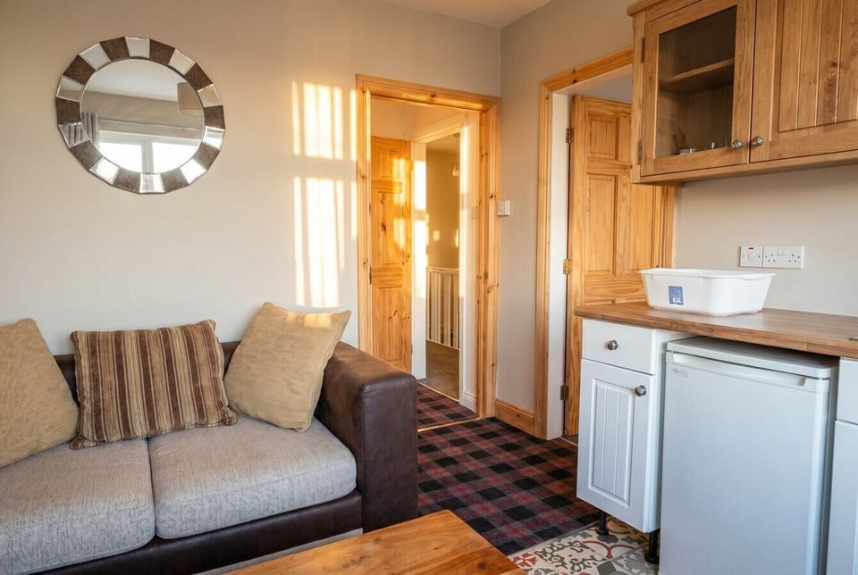 Bright open-plan lounge and kitchenette flooded with warm afternoon sun.