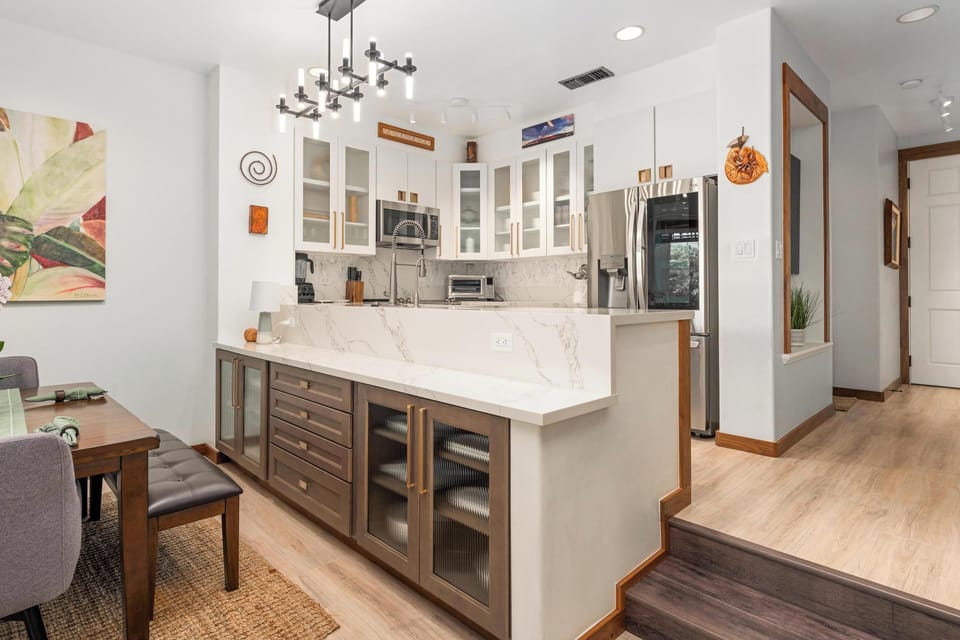 Your gourmet kitchen features sleek white cabinets, marble countertops, and modern appliances perfect for preparing memorable meals during your stay.