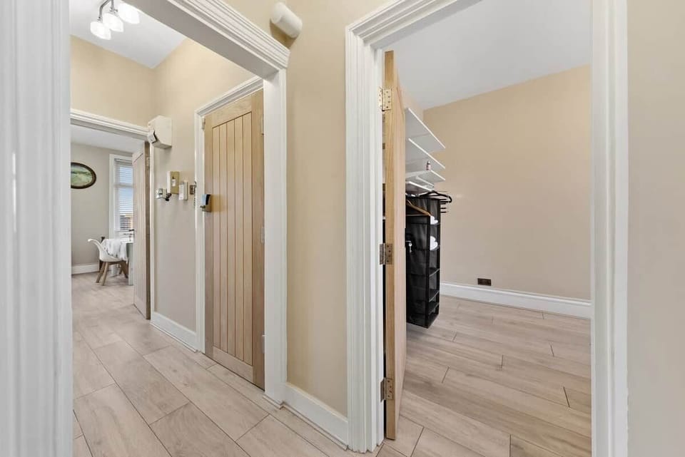 Welcoming hallway leading to the living room and kitchen at one end, and to the bedrooms and bathroom at the other.