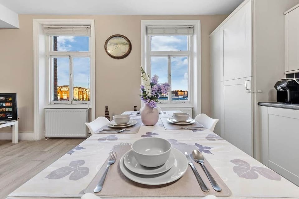 Bright open plan dining area seamlessly connected to the living room and kitchen, that comfortably seats four, while large sash windows offer views over the renowned Queen’s Tennis Club, enhancing the light filled and spacious feel.