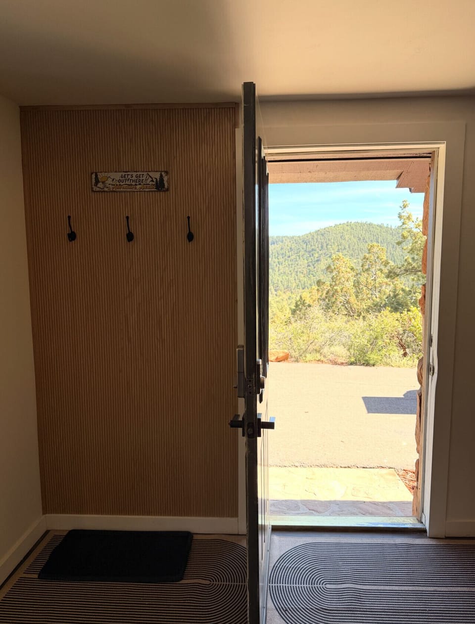A welcoming entryway with coat hooks and a door that opens straight to sweeping mountain views — adventure starts here.